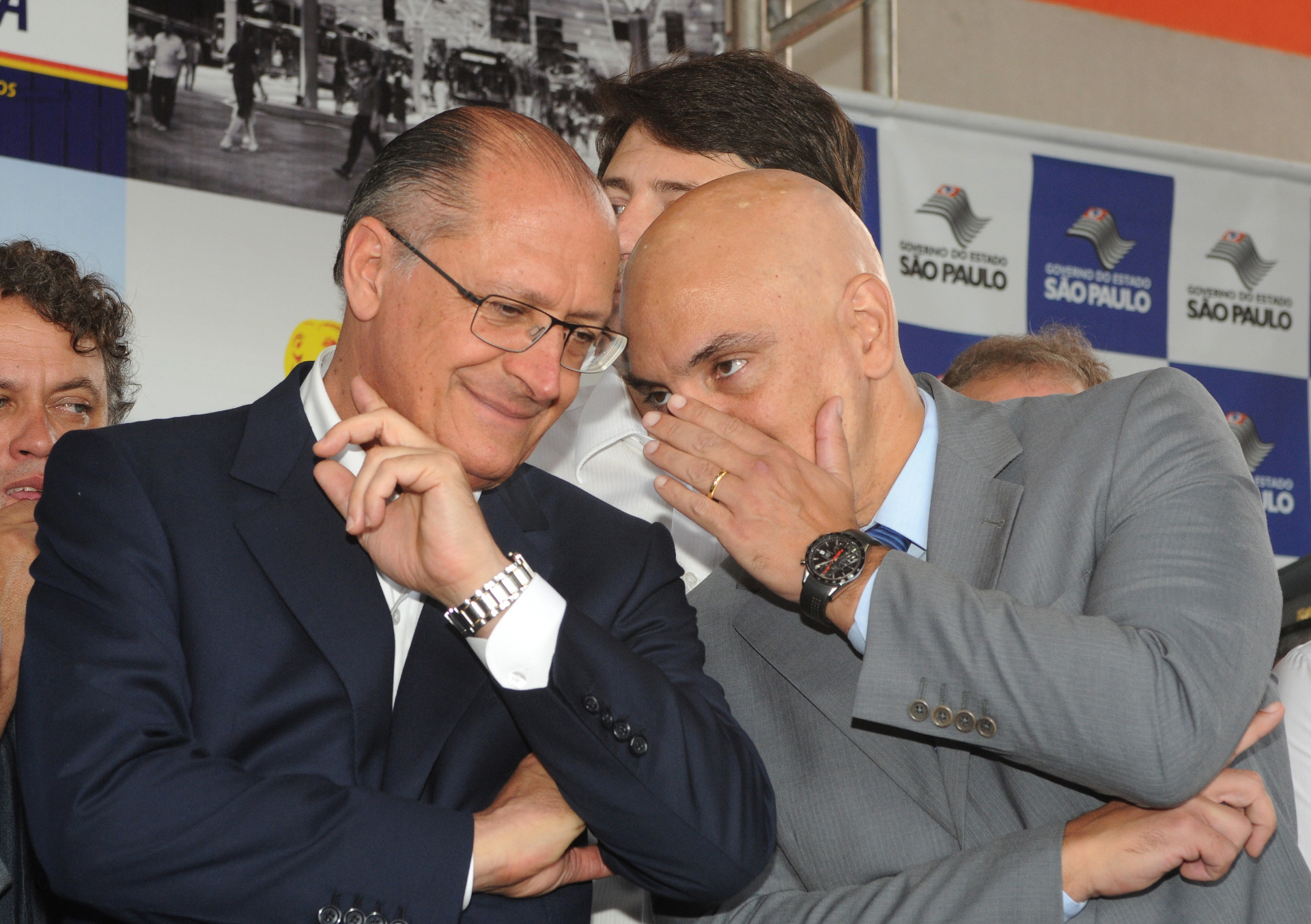 Secretário de segurança do estado de São Paulo, comenta algo no ouvido do governador do estado Geraldo Alckmim